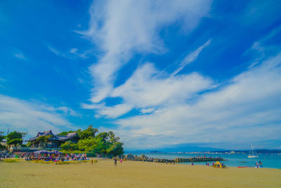 People at beach against sky