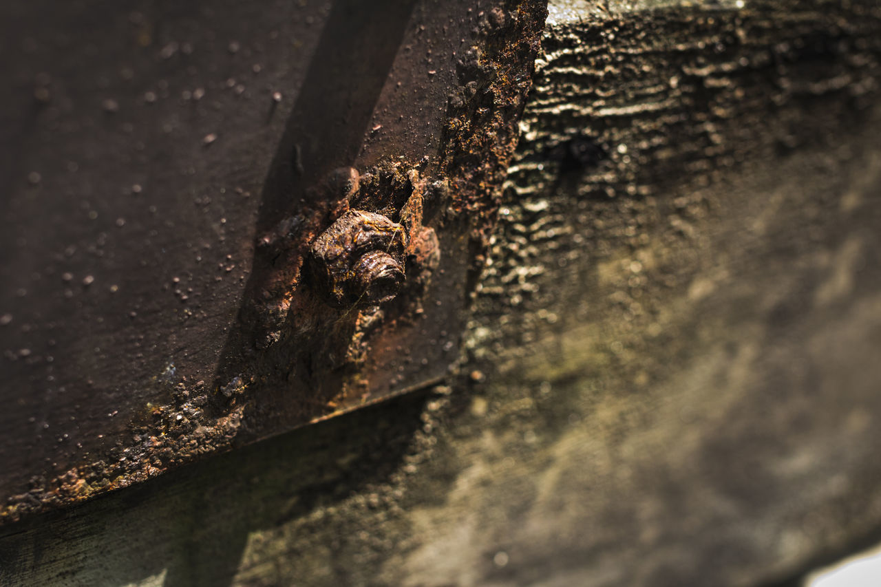 CLOSE-UP OF RUSTY METAL ON WOOD