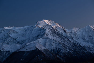 Scenic view of snowcapped mountains against clear sky