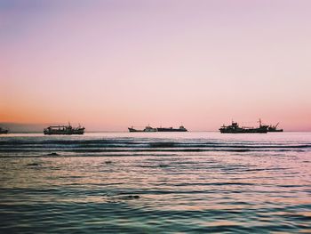 Boats on sea against sky during sunset