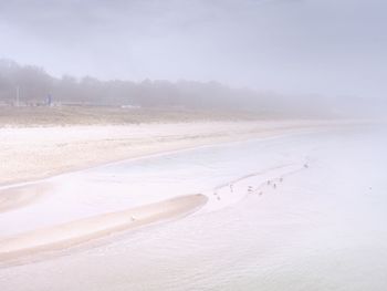Scenic view of beach against sky during winter
