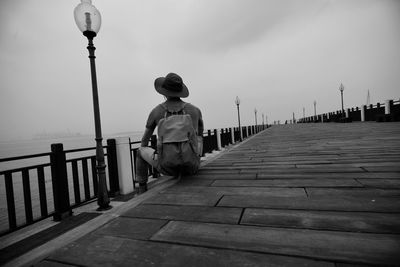 Rear view of man walking on footpath