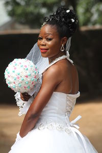 Side view of bride holding bouquet