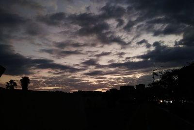 Silhouette city against sky during sunset