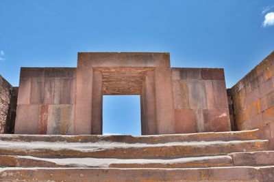 Low angle view of old building against blue sky