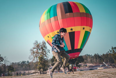 Man levitating against hot air balloon