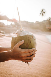 Close-up of person holding umbrella on beach