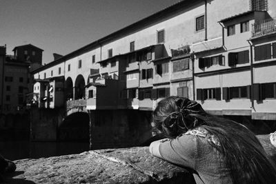 Rear view of woman standing against buildings in city