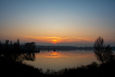 Scenic view of lake against romantic sky at sunset