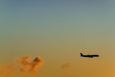 Low angle view of silhouette airplane against sky