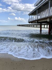 Scenic view of beach and pier against sky