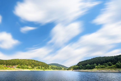 Scenic view of lake by mountains against sky