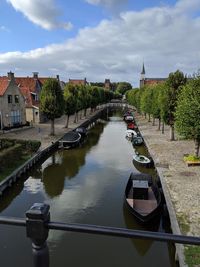 Canal amidst buildings in city against sky