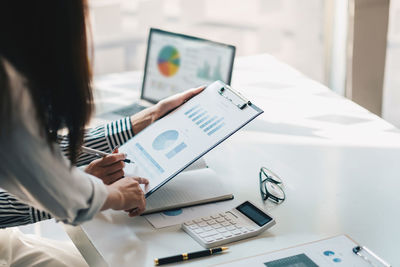 Midsection of businesswoman working at office