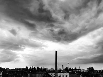 Buildings in city against cloudy sky