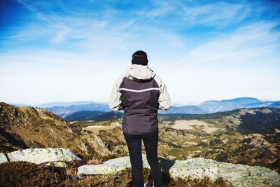 Rear view of woman standing against mountains