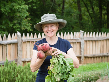 Portrait of smiling young woman holding vegetable