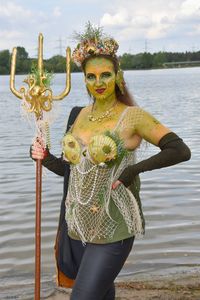 Portrait of woman standing in costume against lake