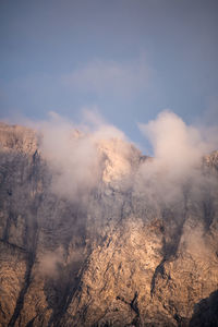 Smoke emitting from mountain against sky