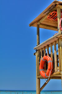 Low angle view of traditional windmill against clear blue sky