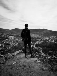 Man standing on a rock after a hike looking over the french rivera