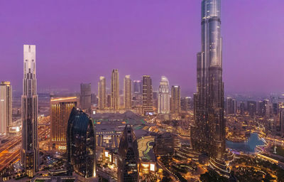 Illuminated cityscape against sky at night