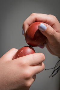 Two hands holding red easter eggs trying to crack the eggs to find the winner. 