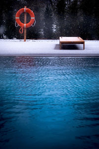 Swimming pool by lake during winter