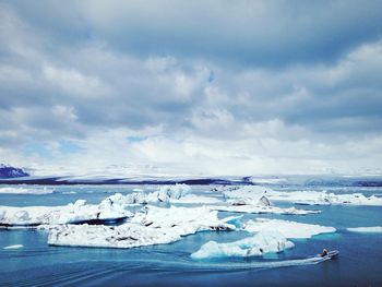 Scenic view of snow covered landscape against cloudy sky