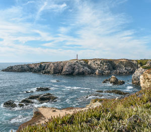 Scenic view of sea against sky. lighthouse on top of cliffs with the ocean in front of it.