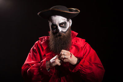 Portrait of man wearing hat against black background