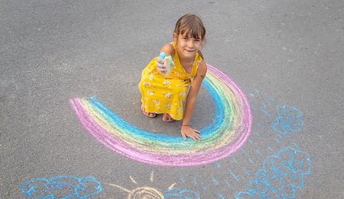 Rear view of girl playing with toy on road