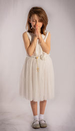 Woman looking away while standing against white background