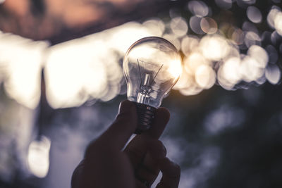 Close-up of hand holding light bulb