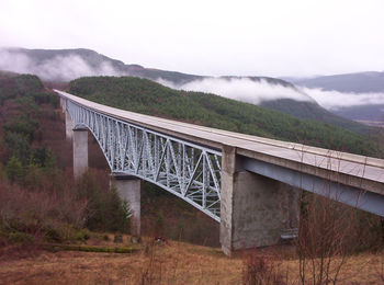 Arch bridge over river against sky