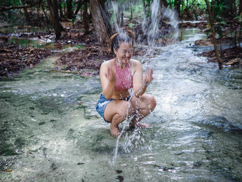 Full length of boy in water at forest