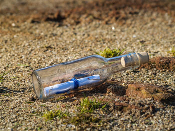 Close-up of note in bottle on field