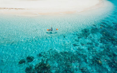 Drone view of man kayaking in sea on sunny day