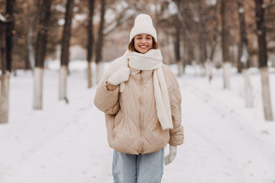 Portrait of woman standing on snow covered field