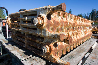 Close-up of rusty machine part against sky