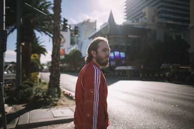 Portrait of young man standing on street in city