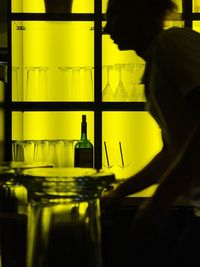 Reflection of man on illuminated bottle