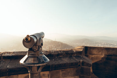 Coin-operated binoculars on mountain against clear sky