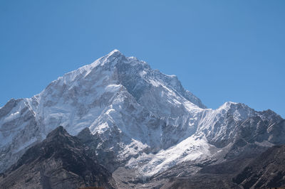 Scenic view of snowcapped mountains against clear blue sky