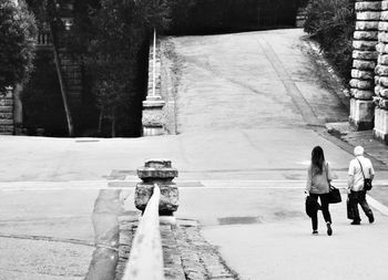 Rear view of people walking on road