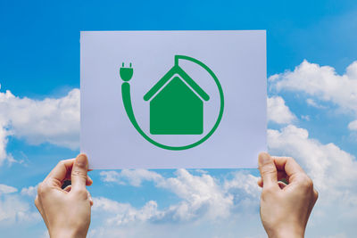 Low section of person holding hands against blue sky