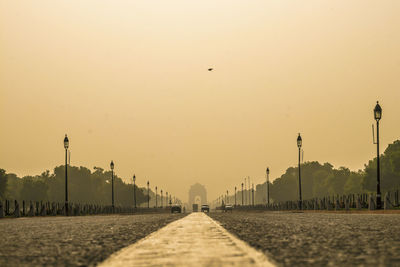 Surface level of road against clear sky during sunset