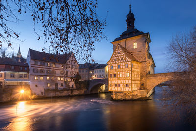 Illuminated buildings against sky at dusk