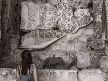 Rear view of woman standing at old ruin