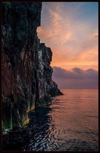 Rocks in sea at sunset